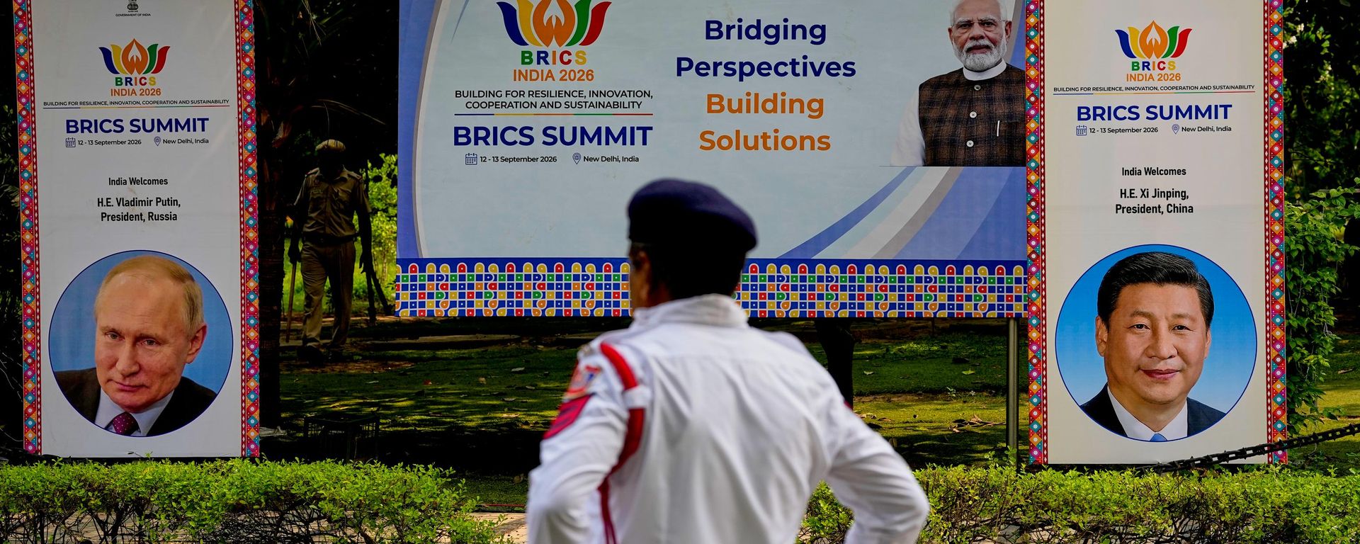 Agentes de seguridad montan guardia junto a pancartas de la cumbre de los BRICS con imágenes del primer ministro indio, Narendra Modi, el presidente ruso, Vladímir Putin, y el mandatario chino, Xi Jinping, en Nueva Deli, India, el 11 de septiembre de 2026 - Sputnik Mundo, 1920, 11.09.2026