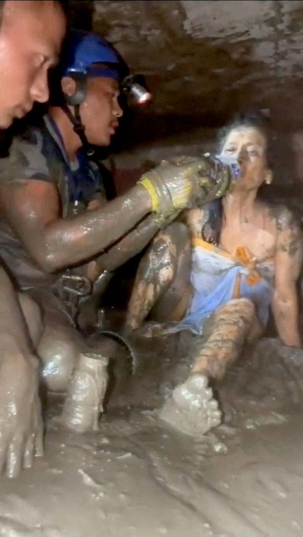 Socorristas ofrecen agua a una mujer rescatada tras las mortíferas inundaciones y el alud en Nepal. - Sputnik Mundo
