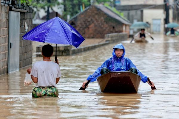 Los residentes locales se desplazan en barco a través de un pueblo inundado a las afueras de Hanói, Vietnam. - Sputnik Mundo