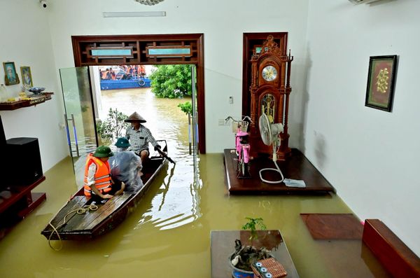 Habitantes locales se desplazan en barco por una carretera inundada de una aldea tras varios días de lluvias, en la provincia de Ninh Binh, Vietnam. - Sputnik Mundo