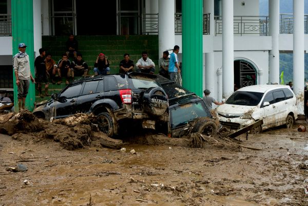 Personas se reúnen cerca de automóviles dañados en una zona afectada por inundaciones repentinas tras las fuertes lluvias, en la provincia de Sumatra Occidental, Indonesia. - Sputnik Mundo