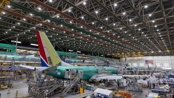 Los empleados de Boeing trabajan en un avión 737 MAX en la línea de ensamblaje final en la planta de Boeing en EEUU - Sputnik Mundo