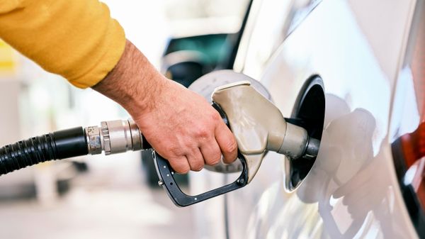 Un hombre bombeando gasolina a su automóvil en una gasolinera - Sputnik Mundo