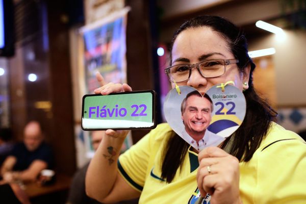 Él afirmó que veía una "posibilidad real" de victoria y calificó el resultado como "el fin de la era del Partido de los Trabajadores".En la foto: Una seguidora de Flavio Bolsonaro posa para una foto mientras espera los resultados electorales en Río de Janeiro. - Sputnik Mundo