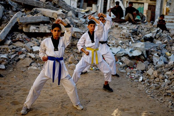 Jóvenes palestinos entrenan taekwondo cerca de una vivienda destruida durante la guerra, en Nuseirat, en el centro de la Franja de Gaza. - Sputnik Mundo