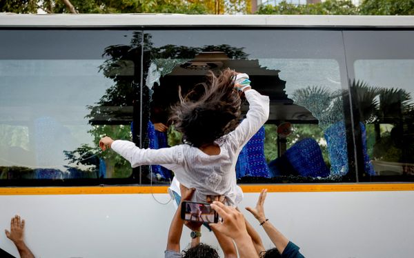 Un manifestante salta por la ventana rota de un autobús durante una protesta contra las presuntas agresiones de la Policía a manifestantes y periodistas y para exigir la dimisión del jefe de la Comisión Electoral, Gyanesh Kumar, en Nueva Deli, India. - Sputnik Mundo
