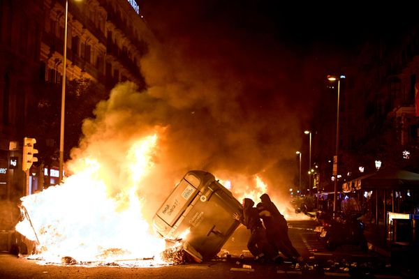 Manifestantes prenden fuego a contenedores de basura durante enfrentamientos con la Policía tras una protesta por la crisis de la vivienda, horas después del anuncio de elecciones anticipadas de Pedro Sánchez, en Barcelona, España. - Sputnik Mundo