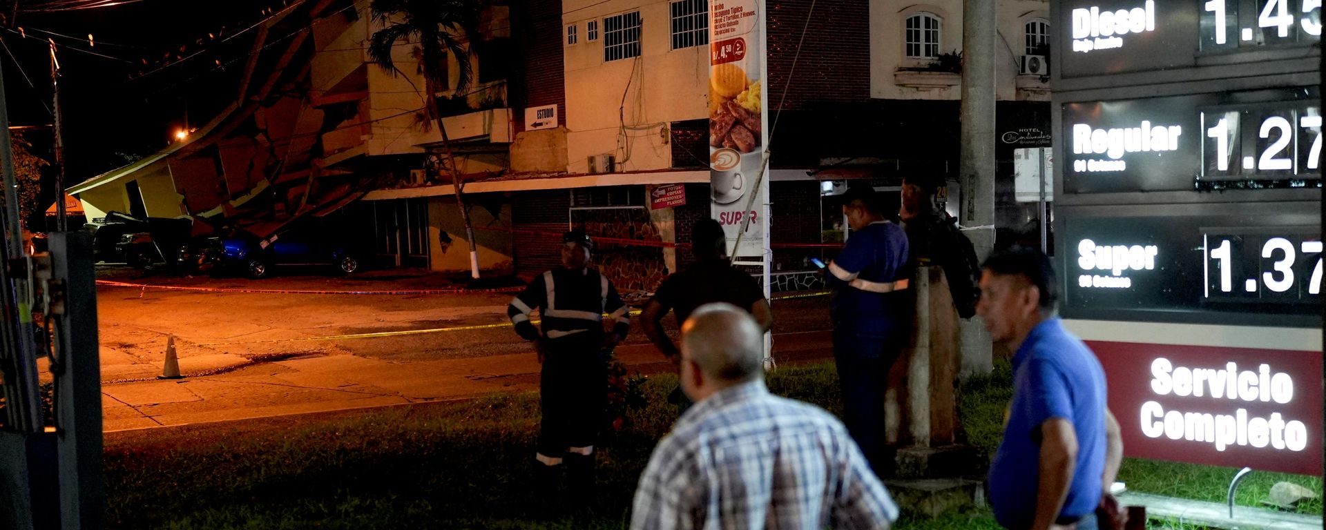 Varias personas permanecen de pie junto a automóviles dañados por la caída de escombros tras un terremoto que sacudió la costa sur de Panamá, en Penonomé, Panamá, el 9 de octubre de 2026  - Sputnik Mundo, 1920, 10.10.2026