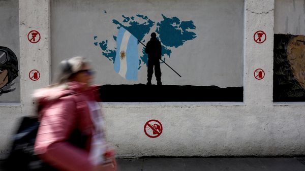 Una mujer pasa frente a un mural que representa a un soldado sosteniendo una bandera argentina ante un mapa de las Islas Malvinas, Buenos Aires, Argentina, 15 de septiembre de 2026  - Sputnik Mundo