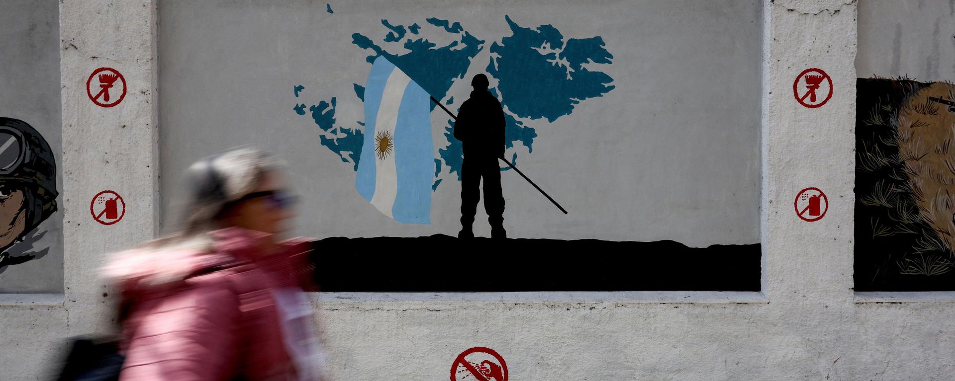Una mujer pasa frente a un mural que representa a un soldado sosteniendo una bandera argentina ante un mapa de las Islas Malvinas, Buenos Aires, Argentina, 15 de septiembre de 2026  - Sputnik Mundo, 1920, 13.10.2026