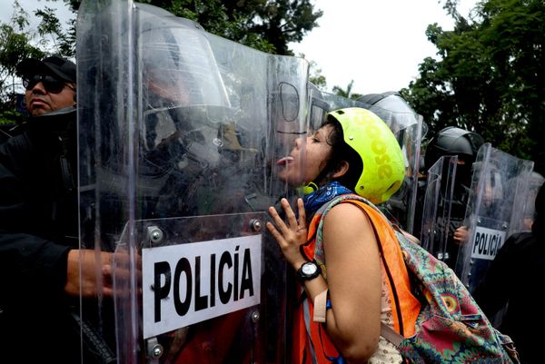 Una manifestante le saca la lengua a un policía antidisturbios durante la protesta en Guadalajara, México. - Sputnik Mundo