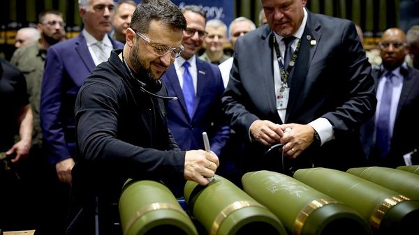 El presidente ucraniano Volodímir Zelenski es observado por Rich Hansen, representante del comandante de la Planta de Municiones de Scranton, mientras firma un documento en Pensilvania, el 22 de septiembre de 2024. - Sputnik Mundo