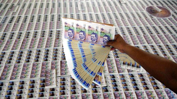 Un agente de policía muestra billetes falsificados de pesos colombianos incautados durante una presentación a los medios de comunicación en Medellín, Colombia, el 18 de septiembre de 2009  - Sputnik Mundo