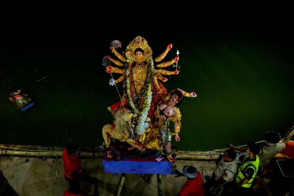 Trabajadores municipales sumergen una estatua de la diosa hindú Durga en las aguas del Brahmaputra durante la jornada de clausura del festival de Durga Puja, en la ciudad india de Guwahati. - Sputnik Mundo