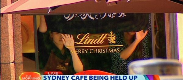 Bandera negra con la inscripción en árabe colocada en le ventana de Lindt Chocolat Café, Australia, 15 de diciembre, 2014 Bandera negra con la inscripción en árabe colocada en le ventana de Lindt Chocolat Café, Australia, 15 de diciembre, 2014 - Sputnik Mundo