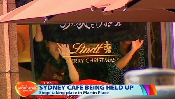 Bandera negra con la inscripción en árabe colocada en le ventana de Lindt Chocolat Café, Australia, 15 de diciembre, 2014 - Sputnik Mundo