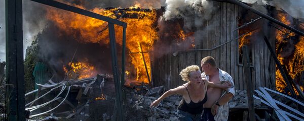 Vecinos del poblado de Lugánskaya, en Donbás, salvándose de un incendio provocado por bombardeos aéreos ucranianos (archivo) Vecinos del poblado de Lugánskaya, en Donbás, salvándose de un incendio provocado por bombardeos aéreos ucranianos (archivo) - Sputnik Mundo