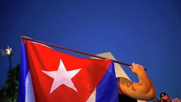 An anti-Castro Cuban exile holds a Cuban flag during a protest after the announcement of restoring diplomatic ties between Cuba and United States, at an area knows as 'Little Havana' in downtown Miami, Florida December 17, 2014.