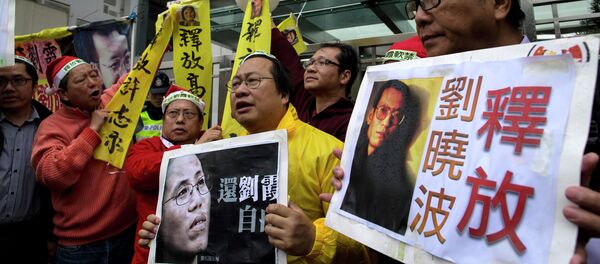 Manifestantes con los carteles del premio Nobel de la Paz Liu Xiaobo y a su mujer Liu Xia Manifestantes con los carteles del premio Nobel de la Paz Liu Xiaobo y a su mujer Liu Xia - Sputnik Mundo