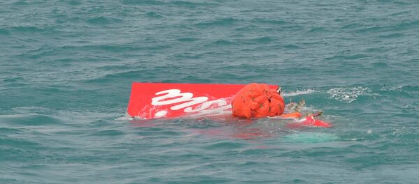 Part of the tail of AirAsia QZ8501 floats on the surface after being lifted as Indonesian navy divers conduct search operations for the black box flight recorders and passengers and crew of the aircraft, in the Java Sea January 10, 2015. - Sputnik Mundo