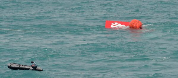 Part of the tail of AirAsia QZ8501 floats on the surface after being lifted as Indonesian navy divers conduct search operations for the black box flight recorders and passengers and crew of the aircraft, in the Java Sea January 10, 2015. - Sputnik Mundo