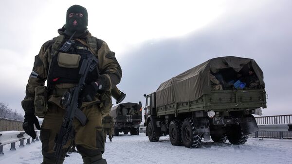 A pro-Russian rebel guards the road near the airport of Donetsk, with Ukrainian military vehicles at rear, Eastern Ukraine, Tuesday, Jan. 6, 2015 - Sputnik Mundo