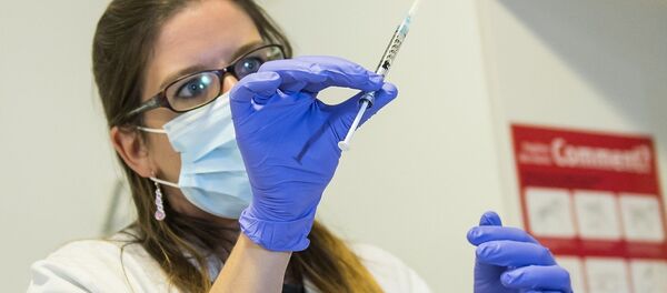 A nurse holds a dose of experimental vaccine cAd3-EBOZ Lau - Sputnik Mundo