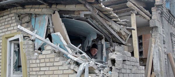 A man removes debris inside his house, which according to locals was recently damaged by shelling, in Donetsk, eastern Ukraine - Sputnik Mundo