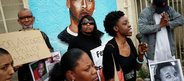 Demonstrators rally against the Missouri grand jury's decision to not indict Darren Wilson for his fatal shooting of Michael Brown, in front of a mural of Ezell Ford Demonstrators rally against the Missouri grand jury's decision to not indict Darren Wilson for his fatal shooting of Michael Brown, in front of a mural of Ezell Ford - Sputnik Mundo