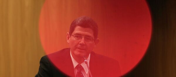 Brazil's Finance Minister Joaquim Levy, pictured through a red LED light of a camera, reacts during a news conference at Brazil's Central Bank in Brasilia January 5, 2015. - Sputnik Mundo