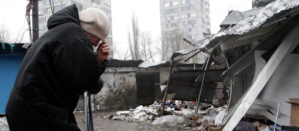 A woman reacts as she stands at a market, which according to locals was recently damaged by shelling, in Donetsk, eastern Ukraine January 19, 2015 - Sputnik Mundo