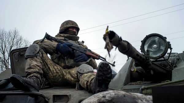 A Ukrainian serviceman rides on APC - Sputnik Mundo