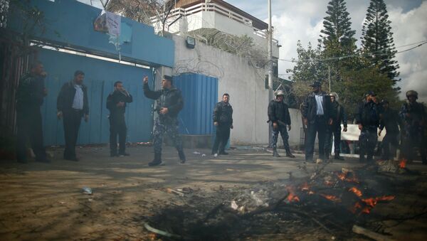 Palestinian policemen loyal to Hamas stand guard after Palestinians attacked the headquarters of the United Nations Special Coordinator during a protest against the decision by the main U.N. aid agency to suspend payments to tens of thousands of Palestinians for repairs to their homes damaged in last summer's war, in Gaza City January 28, 2015 - Sputnik Mundo