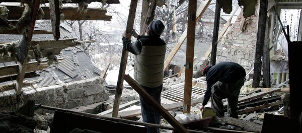 Local residents remove debris at a house damaged by recent shelling in Donetsk, eastern Ukraine, January 21, 2015 - Sputnik Mundo