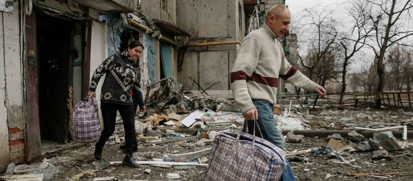 Local residents leave a residential block during a recent shelling, in the town of Yenakieve, February 2, 2015 - Sputnik Mundo