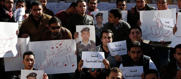Students hold pictures of Islamic State captive Jordanian pilot Muath al-Kasaesbeh - Sputnik Mundo