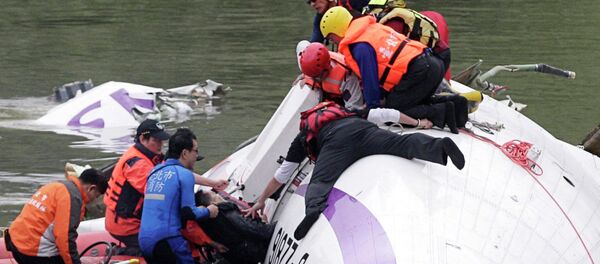 Rescuers pull a passenger out of the TransAsia Airways plane which crash landed in a river, in New Taipei City, February 4, 2015 - Sputnik Mundo