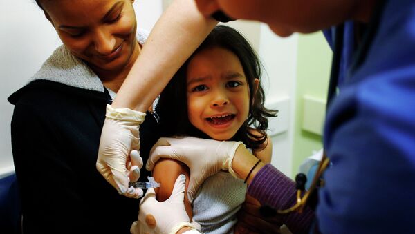 Mercado sitting in his mother's lap while getting an influenza vaccine at Boston Children's Hospital - Sputnik Mundo