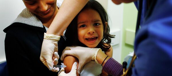 Mercado sitting in his mother's lap while getting an influenza vaccine at Boston Children's Hospital - Sputnik Mundo