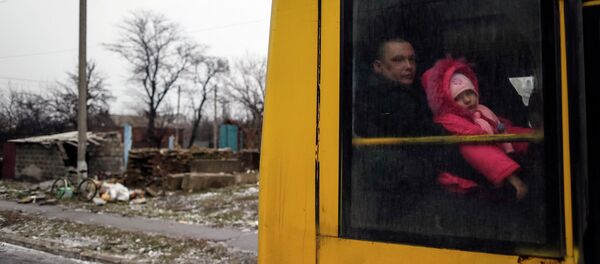 A man and a child look through a bus window before leaving as people flee the conflict in Debaltseve, eastern Ukraine, February 6, 2015. - Sputnik Mundo