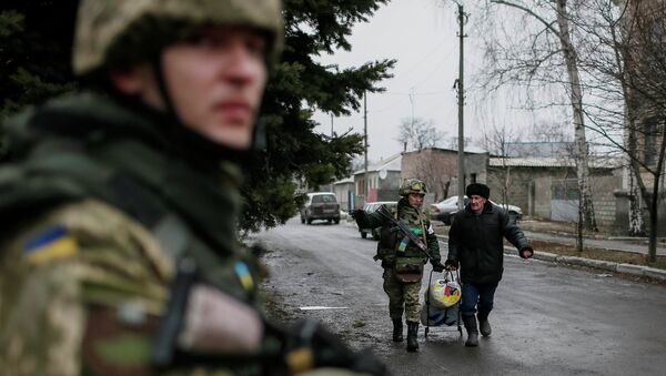 A member of the Ukrainian armed forces assists a local resident onto a bus to flee the military conflict, in Debaltseve, February 6, 2015 - Sputnik Mundo