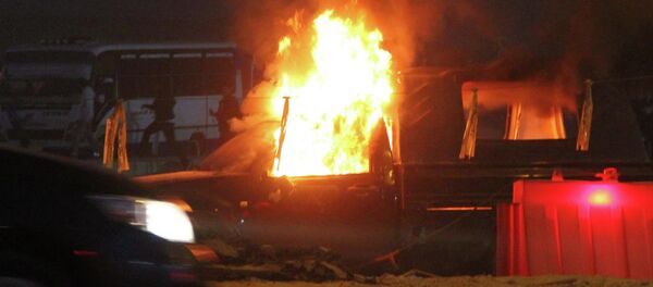 Soccer fans run behind a police car, which was set on fire by fireworks, during clashes between soccer fans and security forces in front of a stadium on the outskirts of Cairo February 8, 2015 - Sputnik Mundo