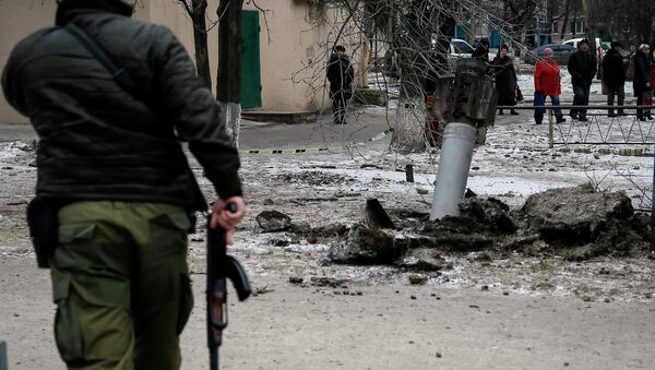 A Ukrainian serviceman guards the street next to the remains of a rocket shell in the town of Kramatorsk,February 10, 2015 - Sputnik Mundo