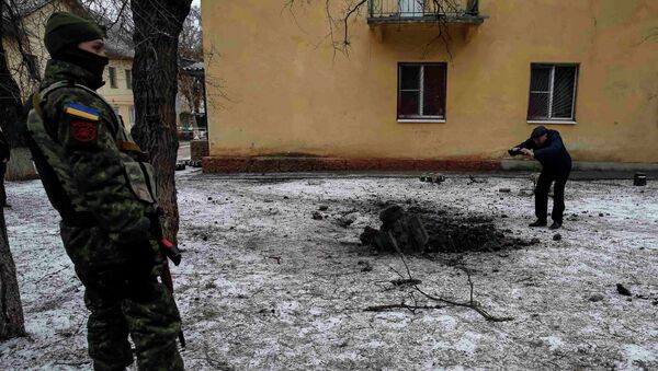 A Ukrainian serviceman guards the street next to the remains of a rocket shell in the town of Kramatorsk, February 10, 2015 - Sputnik Mundo