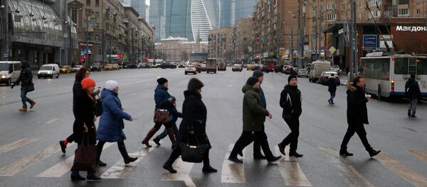 La gente cruza la calle, mientras los edificios del centro de negocios internacional de Moscú se ve en el fondo La gente cruza la calle, mientras los edificios del centro de negocios internacional de Moscú se ve en el fondo - Sputnik Mundo