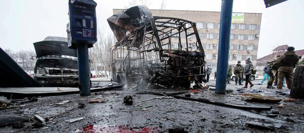 Destroyed vehicles, debris and blood on the ground are seen at a bus station after shelling in Donetsk, February 11, 2015 - Sputnik Mundo
