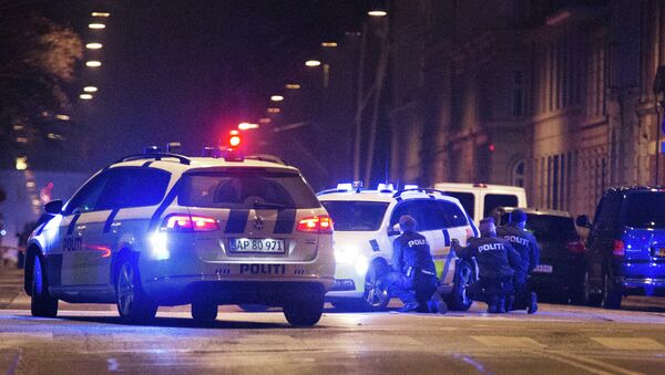 Police officers take cover behind their patrol cars on the streets of central Copenhagen on February 15, 2015 - Sputnik Mundo