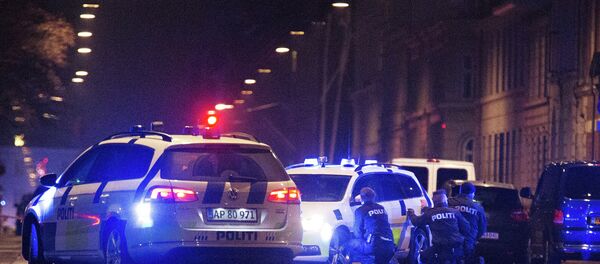 Police officers take cover behind their patrol cars on the streets of central Copenhagen on February 15, 2015 - Sputnik Mundo