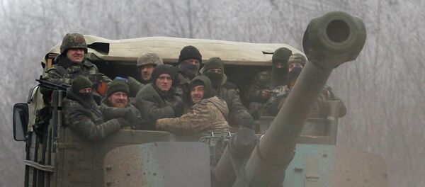 Ukrainian government soldiers ride on a vehicle on the road between the towns of Dabeltseve and Artemivsk, Ukraine, Saturday, Feb. 14, 2015 Ukrainian government soldiers ride on a vehicle on the road between the towns of Dabeltseve and Artemivsk, Ukraine, Saturday, Feb. 14, 2015 - Sputnik Mundo