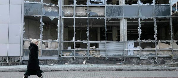 A woman walks by a building, which was damaged by shelling last September, in Donetsk, February 15, 2015 - Sputnik Mundo
